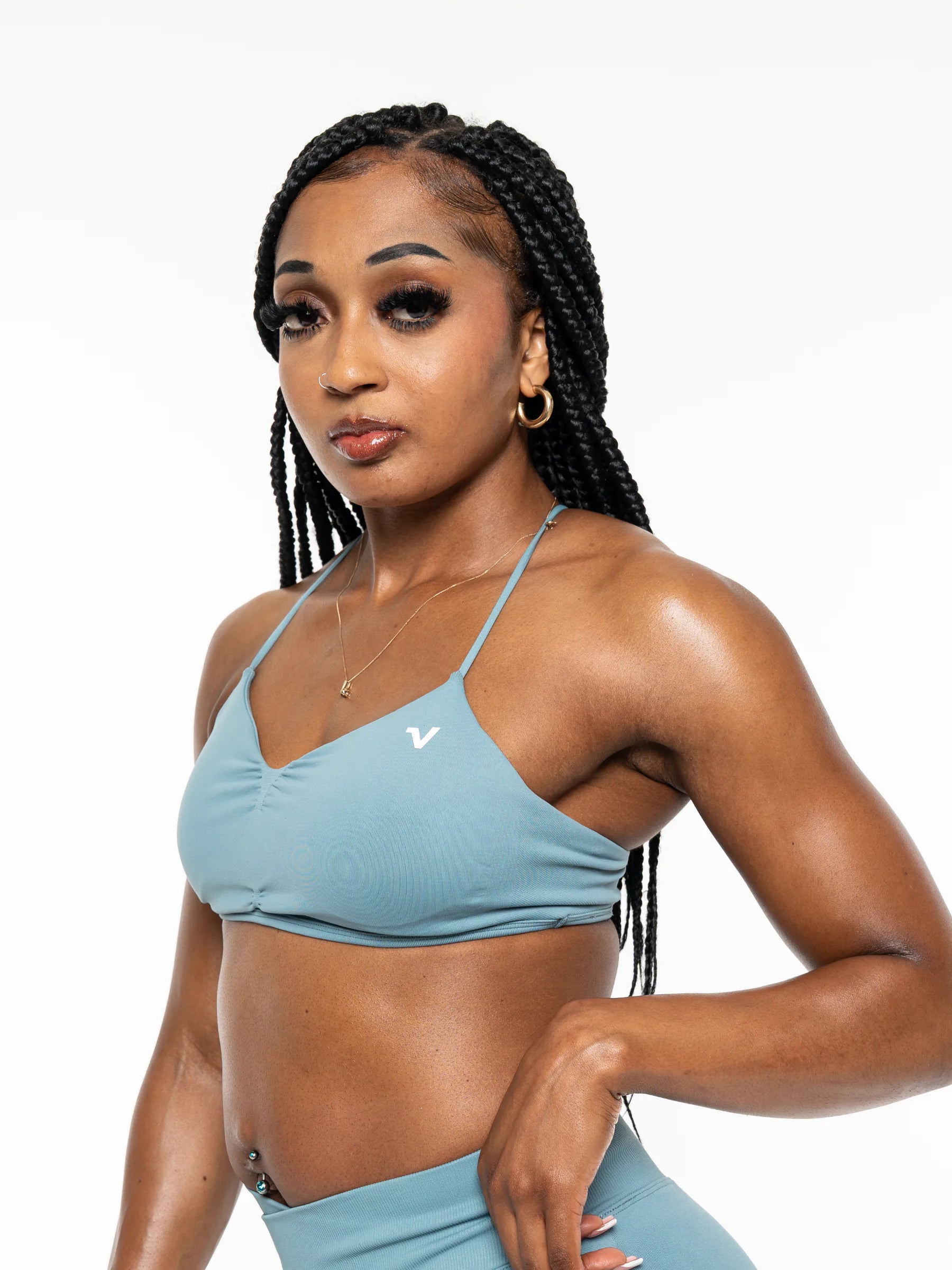 Veritone Ease Bra, Ocean Mist – A woman modeling a light blue ribbed sports bra and matching high-waisted leggings against a plain white background.