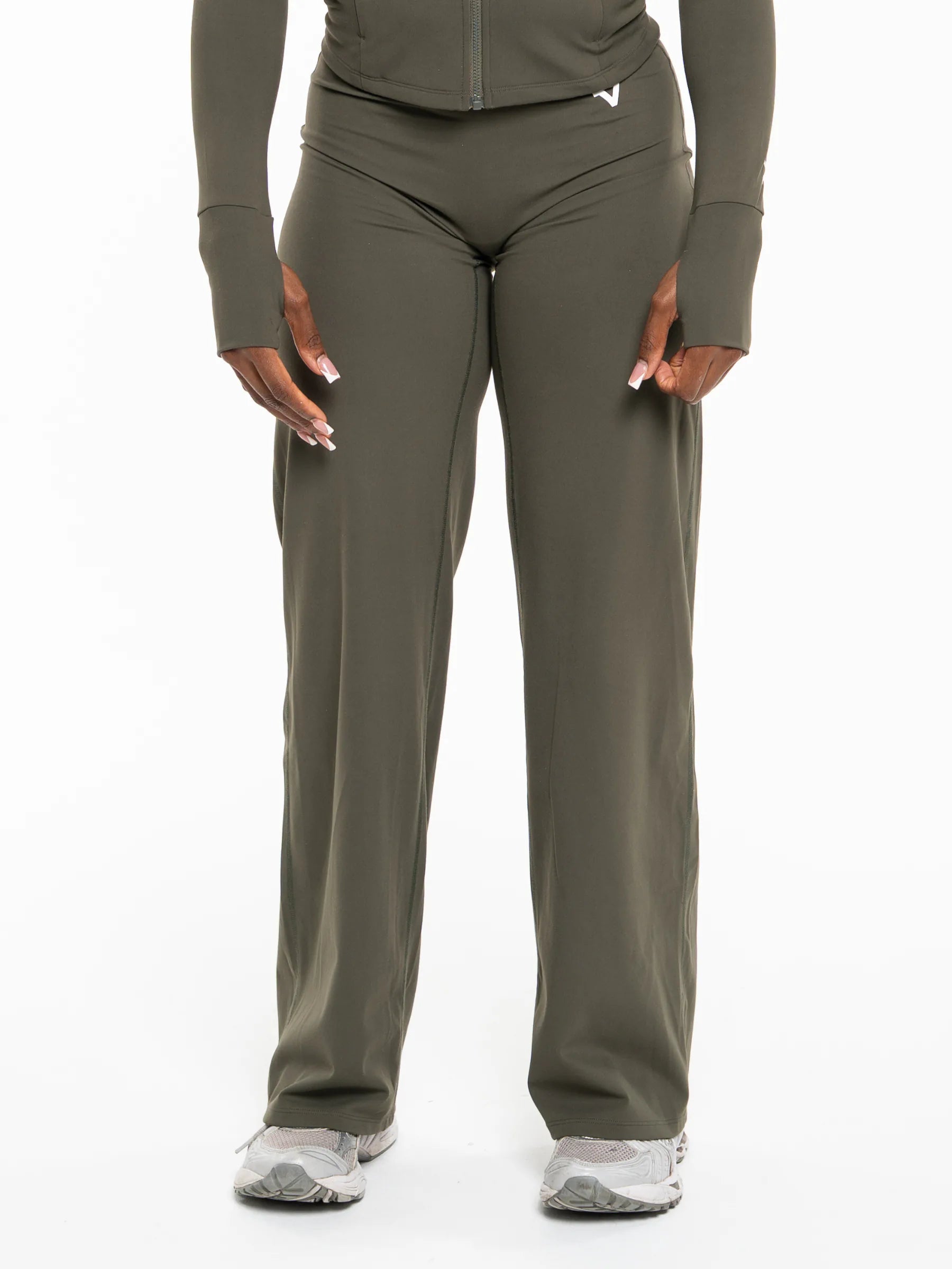 Veritone Élan Flared Pants, Olive Stone – A model wearing olive green athletic pants and a matching long-sleeve top, shown from the waist down against a plain white background.