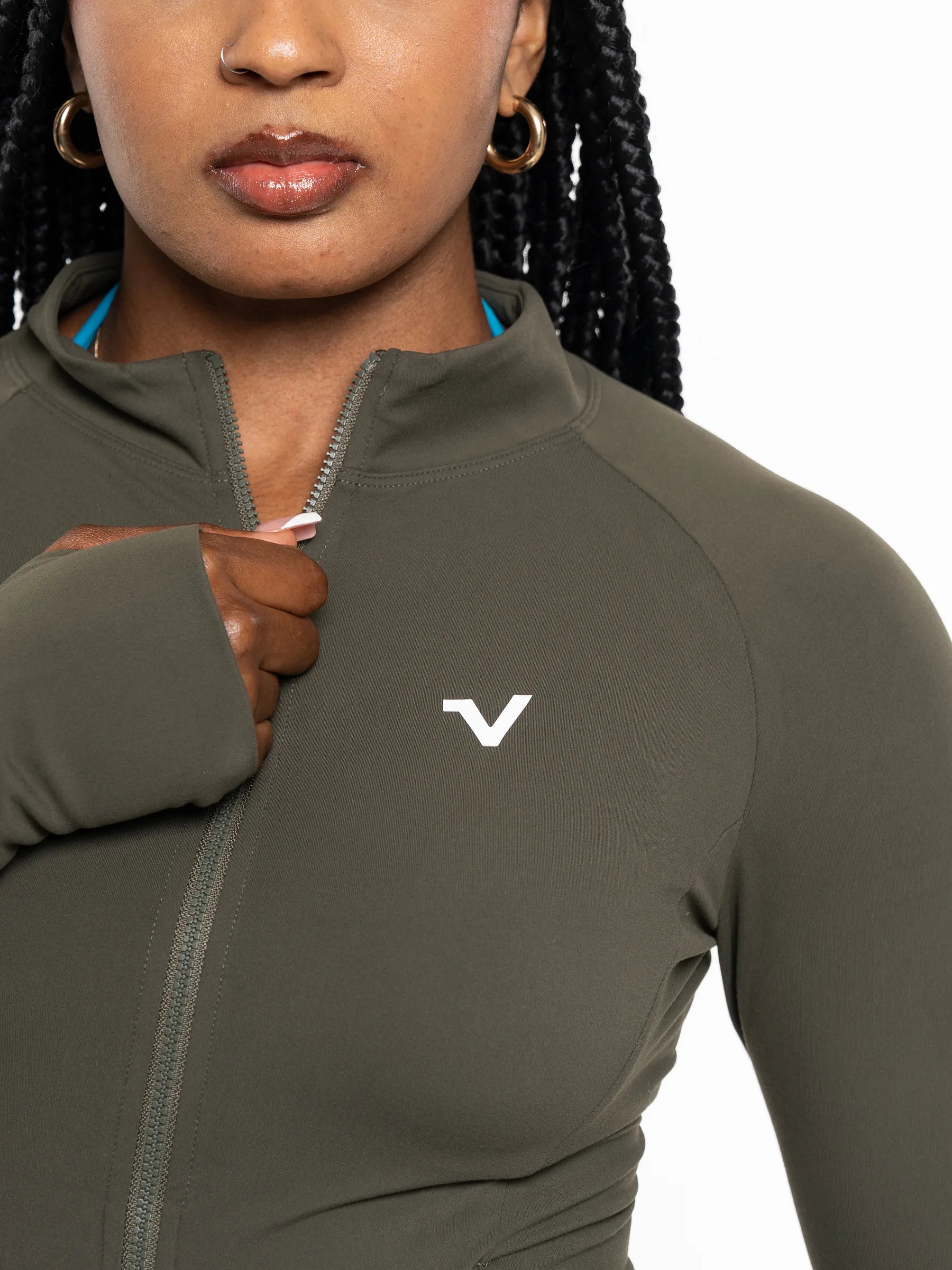 Veritone Élan Jacket, Olive Stone – Close-up of a woman wearing a fitted athletic zip-up top in dark olive green with a white stylized 'V' logo on the chest. The image is cropped from the lower face to the torso against a plain white background.