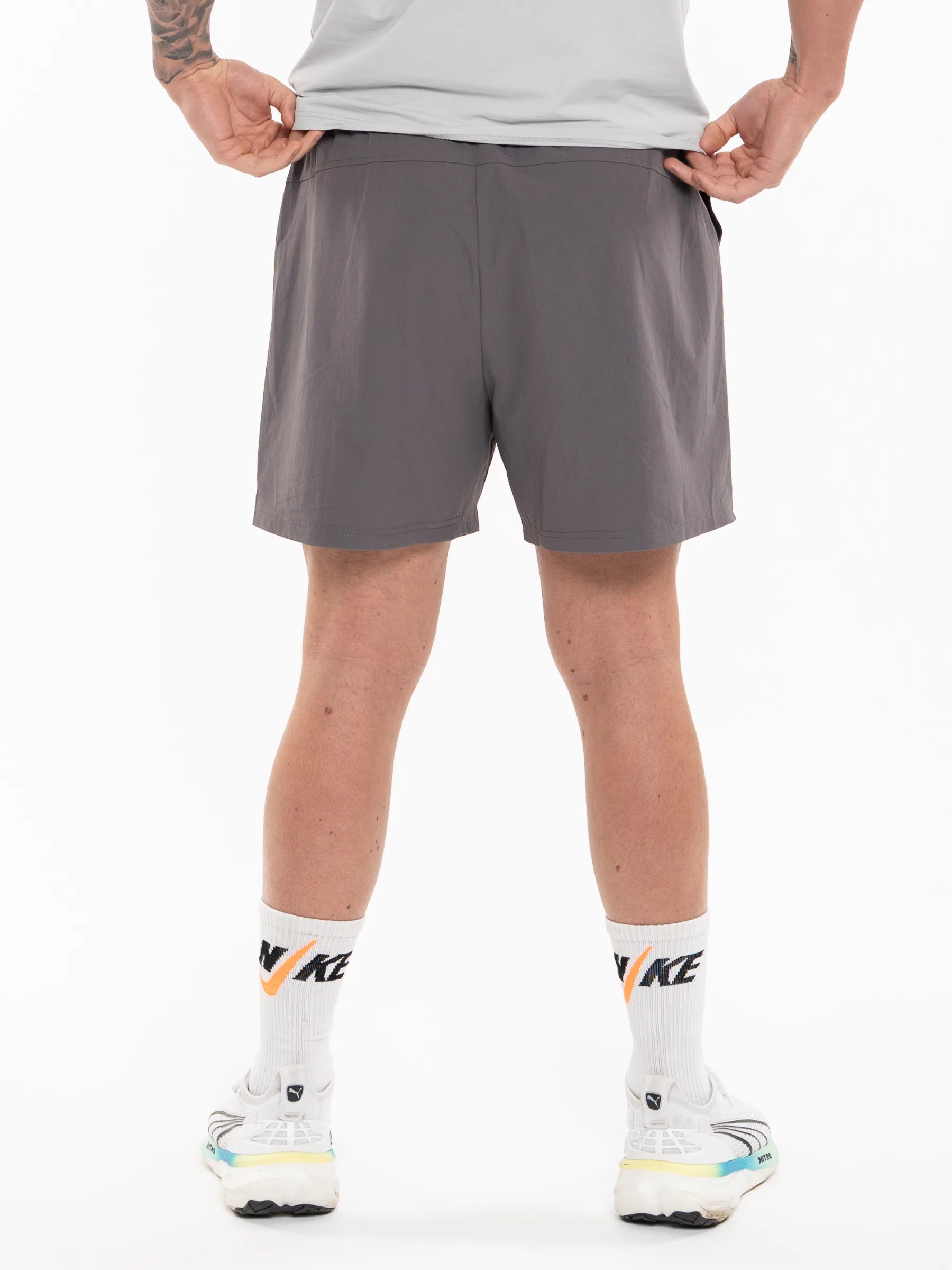 Veritone Essential Training Shorts, Ash Grey – dark gray athletic shorts shown from back, the waist down against a white studio background.