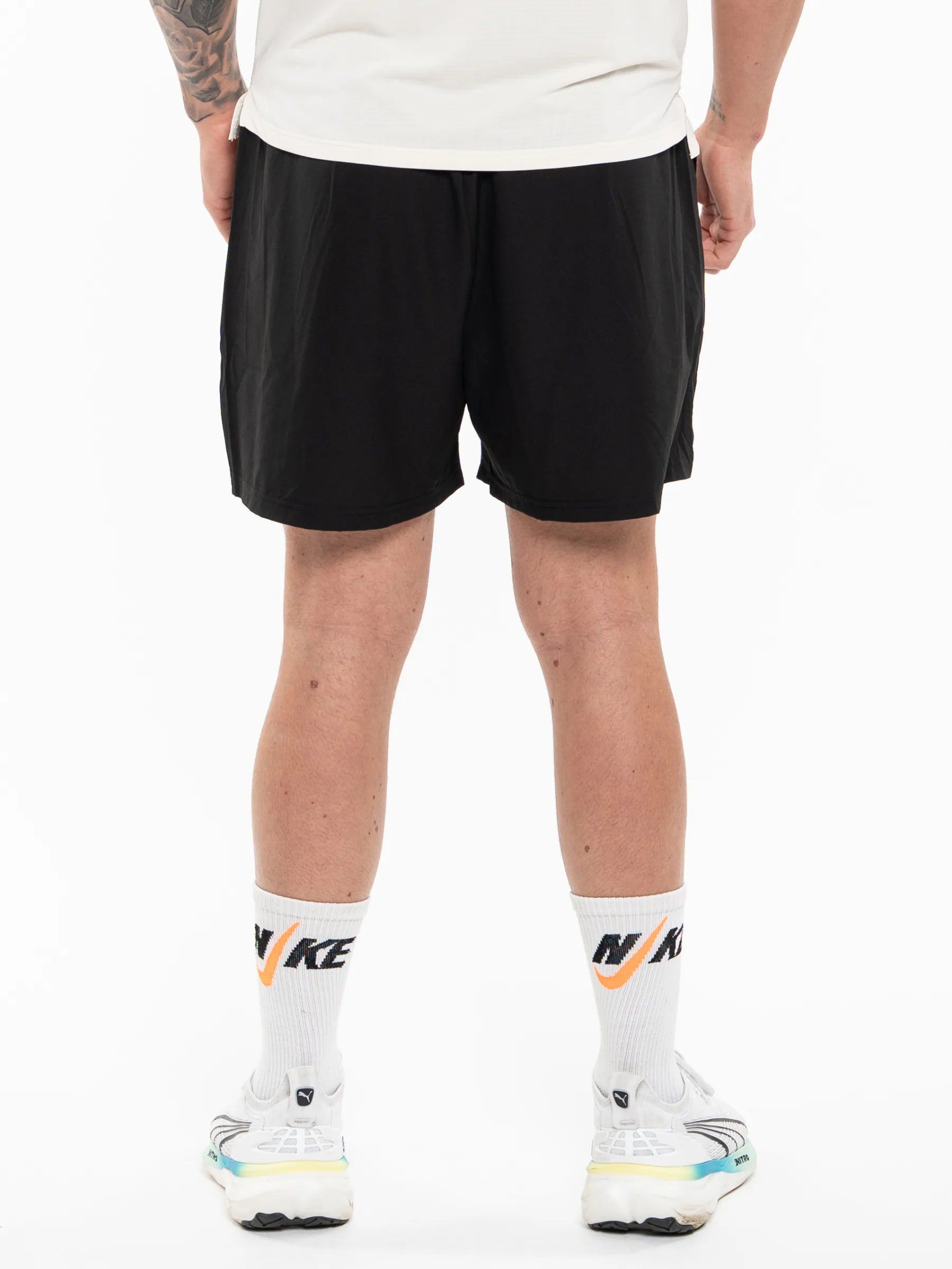 Veritone Essential Training Shorts, Black athletic shorts shown waist down from the back against a white studio background.