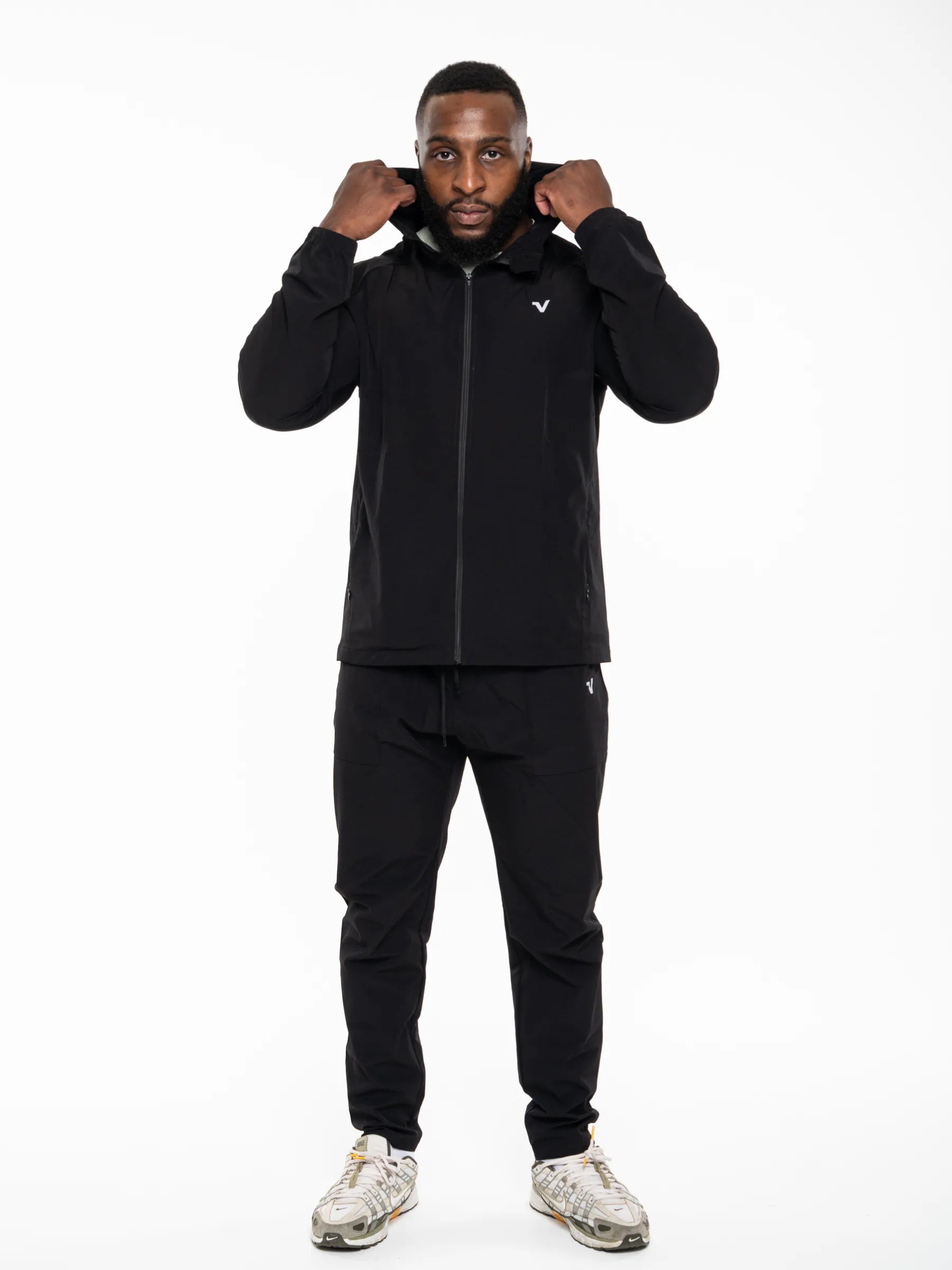 Veritone Mode Jacket, Midnight Black – A man modeling a black zip-up hoodie and matching black sweatpants against a plain white studio background.