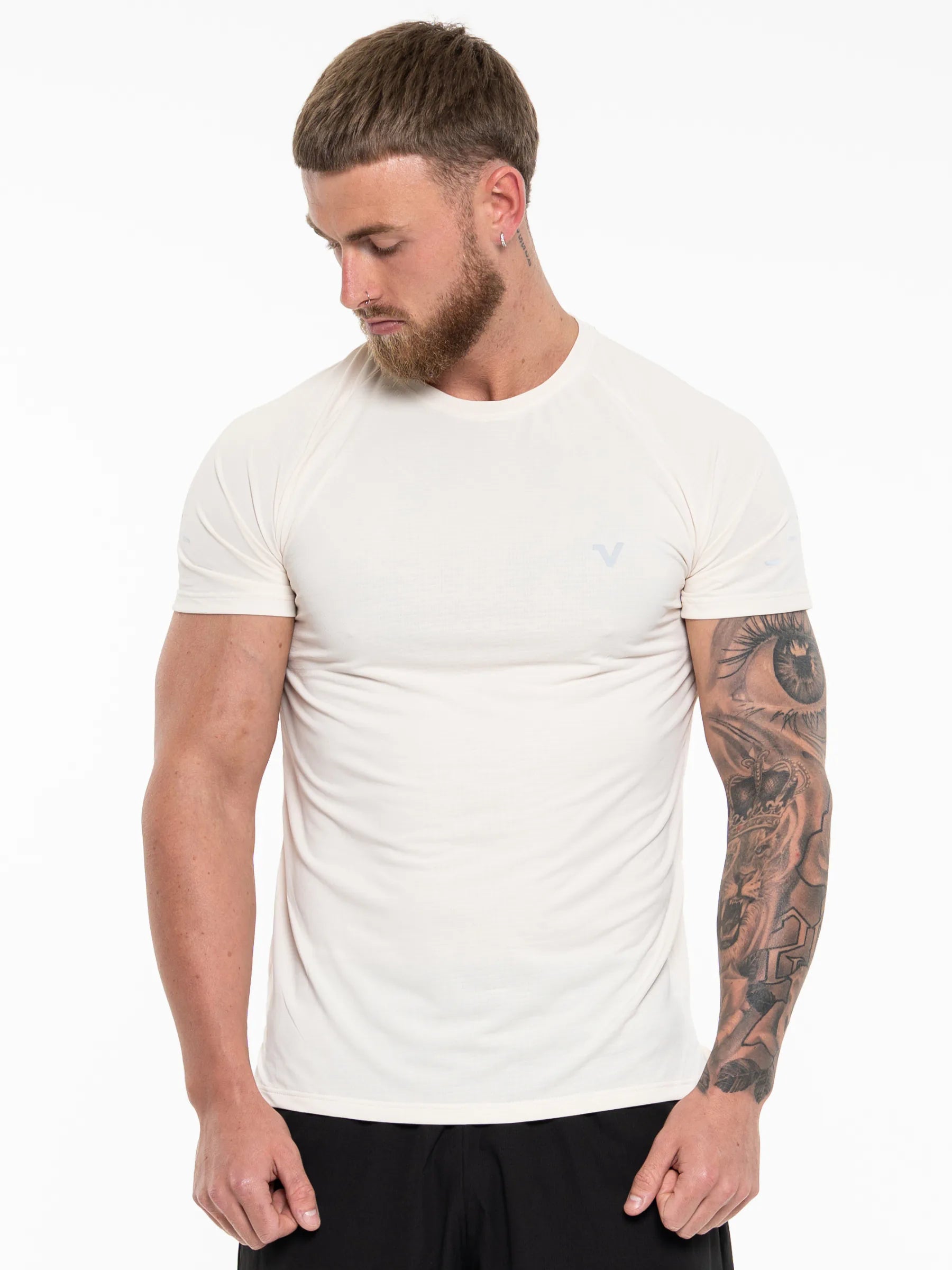 Veritone Prime Core T-Shirt, Cloud Cream – A man wearing a fitted short-sleeve crew-neck t-shirt in off-white, paired with black shorts, photographed against a plain white studio background.