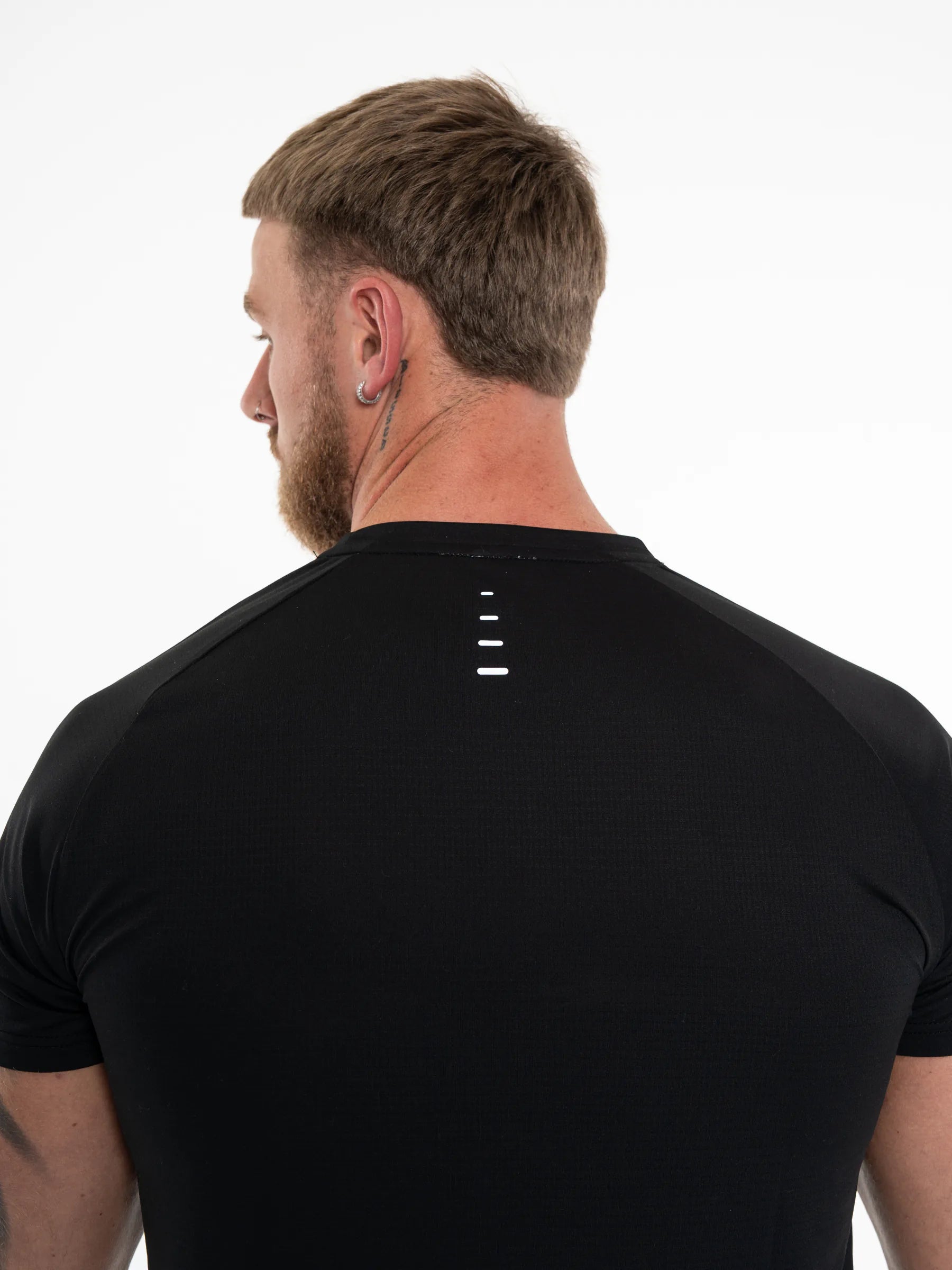 Veritone Prime Core T-Shirt, Midnight Black – Rear view of a man wearing a black athletic t-shirt with a small white dotted graphic on the upper back, set against a plain white background.