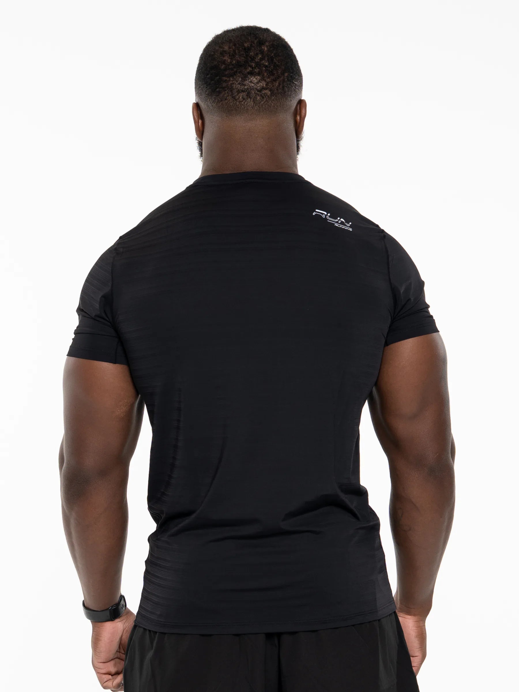 Veritone Prime Muscle Fit T-Shirt, Black – Rear view of a man wearing a black short-sleeve athletic t-shirt with a small white logo on the upper right shoulder, set against a plain white background.