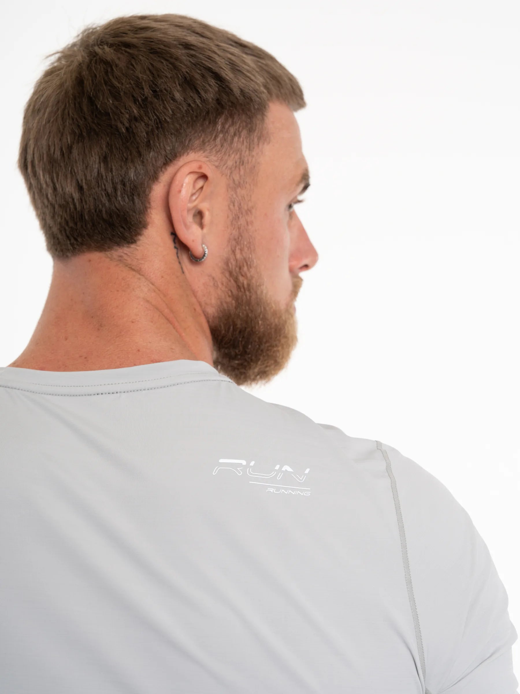 Veritone Prime Muscle Fit T-Shirt, Light Grey – A close-up back view of a man wearing a light gray athletic t-shirt with a subtle white RUN logo printed on the upper back, set against a plain white background.