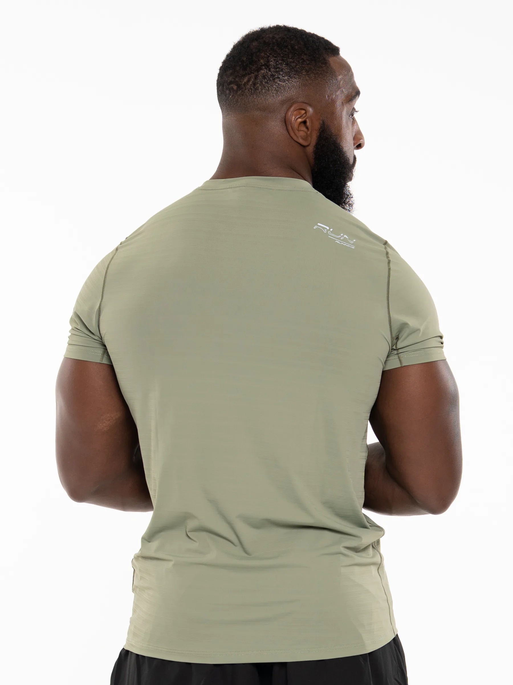 Veritone Prime Muscle Fit T-Shirt, Stone Khaki – Man wearing a green athletic shirt with a brand logo on the back, standing against a white background